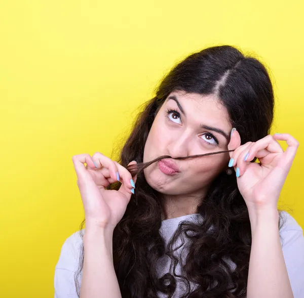 Portrait of funny girl making moustache against yellow backgroun — Stock Photo, Image