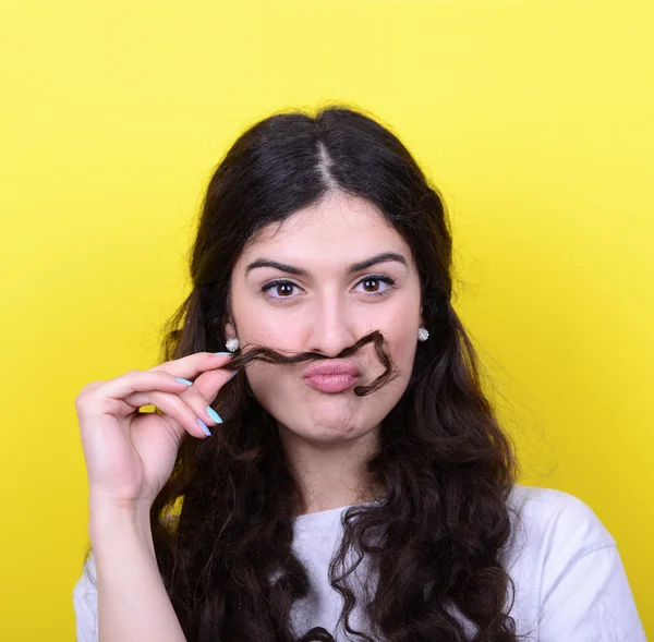 Portrait of funny girl making moustache against yellow backgroun — Stock Photo, Image