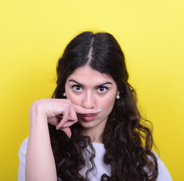 Portrait de fille drôle faisant moustache contre backgroun jaune — Photo