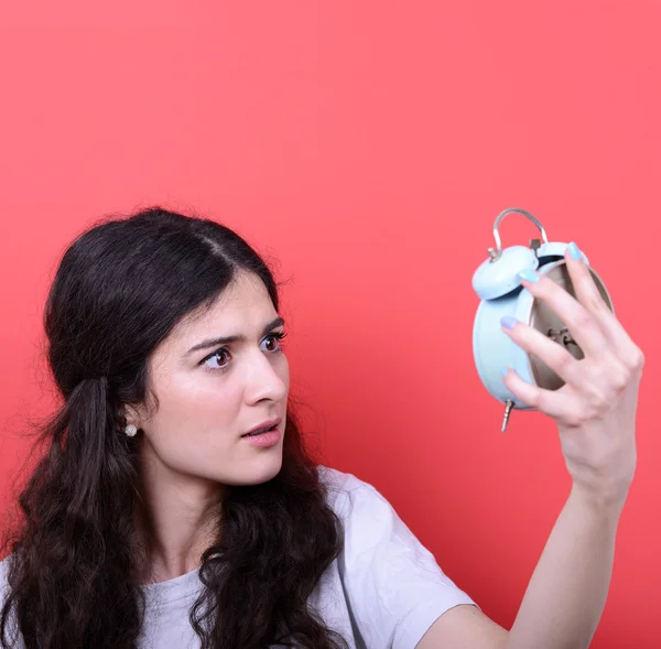 Retrato de chica en el caos mirando asustado al reloj contra rojo ba —  Fotos de Stock