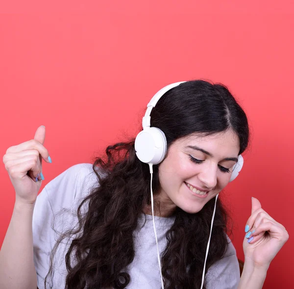 Portrait of happy teen girl dancing and listening music against — Stock Photo, Image