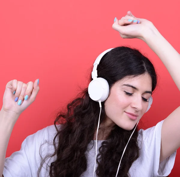 Portrait of happy teen girl dancing and listening music against — Stock Photo, Image