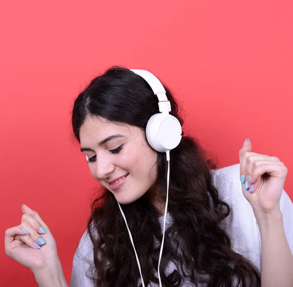 Portrait of happy teen girl dancing and listening music against — Stock Photo, Image