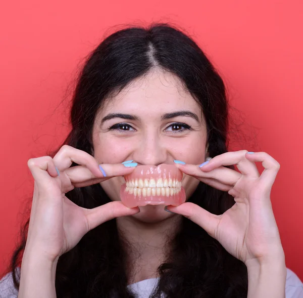 Retrato de mujer feliz con sonrisa sana sosteniendo la prótesis dental de nuevo —  Fotos de Stock