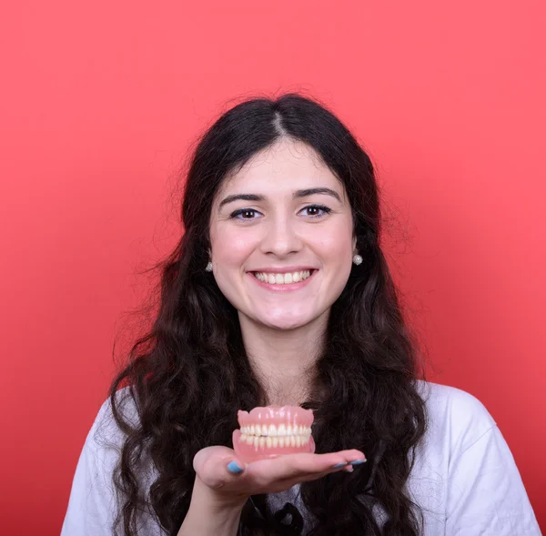 Retrato de mujer feliz con sonrisa sana sosteniendo la prótesis dental de nuevo —  Fotos de Stock