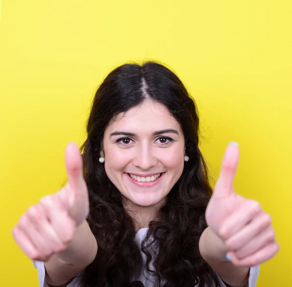 Retrato de mujer feliz con pulgares hacia arriba sobre fondo amarillo — Foto de Stock