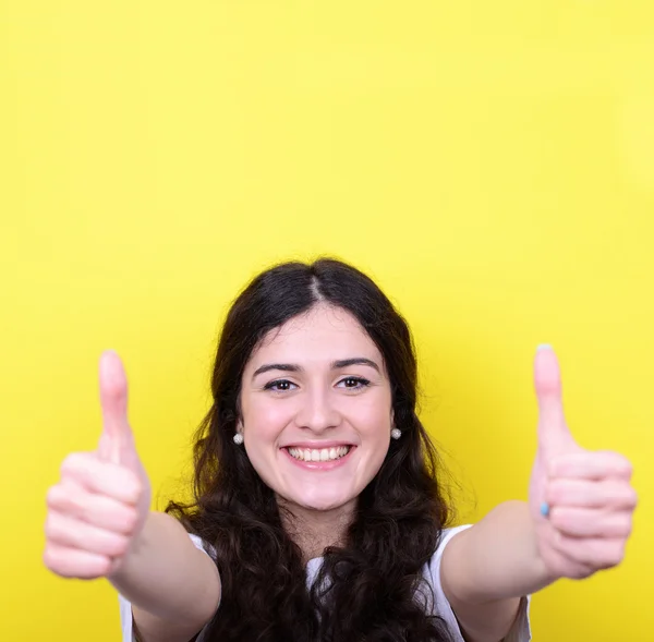 노란 배경에 대하여 엄지손가락으로 행복 한 여자의 초상화 — 스톡 사진