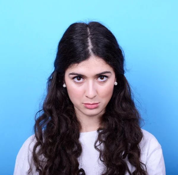 Portrait of sad girl against blue background — Stock Photo, Image