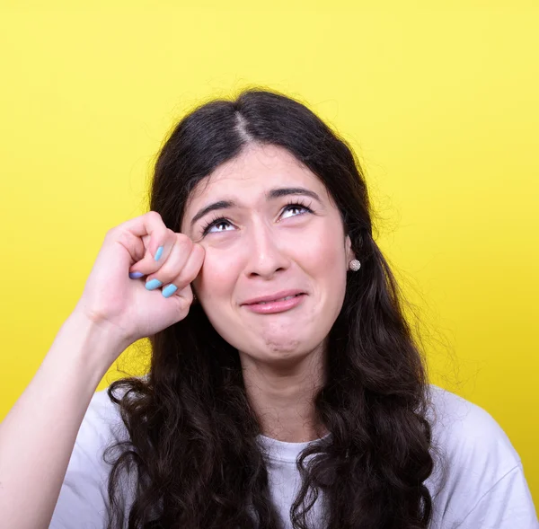 Retrato de mulher chorando e enxugando lágrimas contra backgro amarelo — Fotografia de Stock