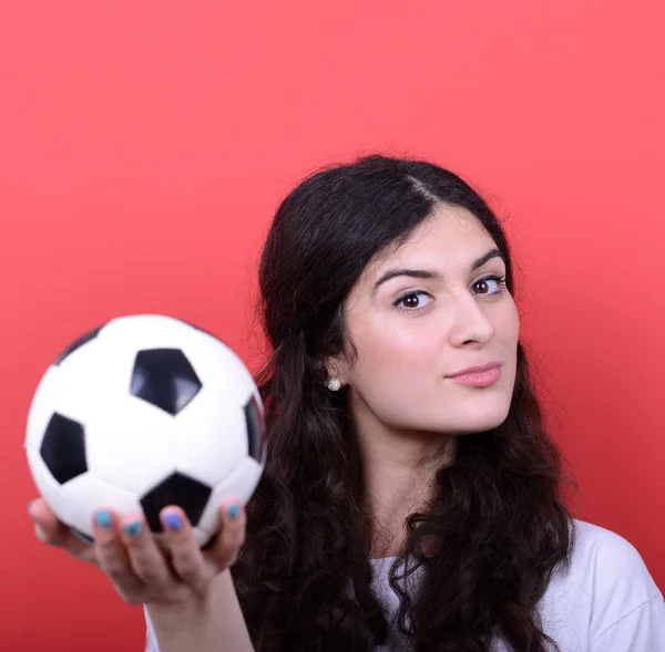 Портрет женщины, держащей футбол на красном фоне — стоковое фото