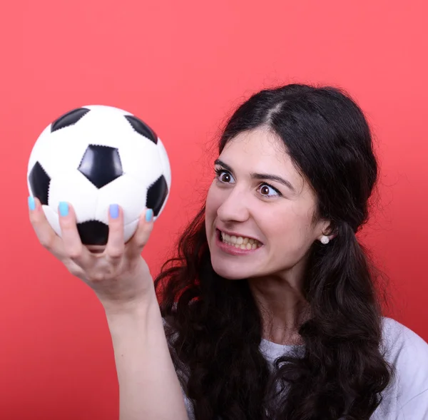 Портрет женщины, держащей футбол и глядящей на него с ненавистью — стоковое фото