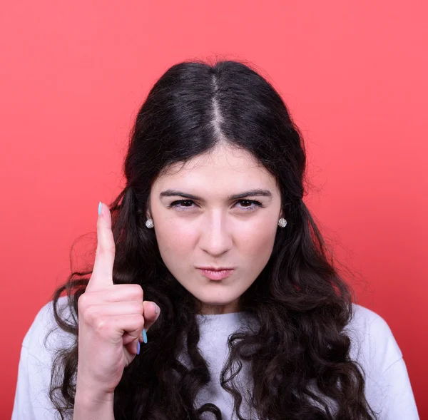 Portrait of woman threatening with finger gesture against red ba — Stock Photo, Image