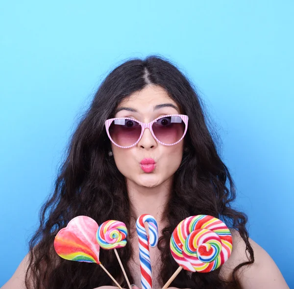 Portrait of woman with retro glasses and lollipops against blue — Stock Photo, Image