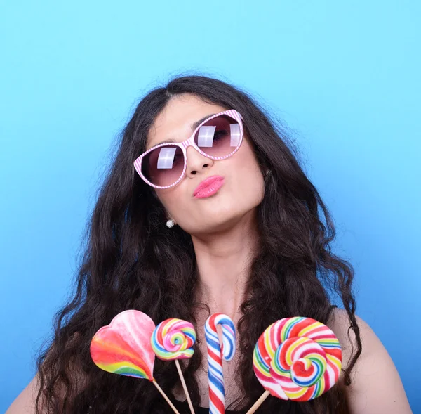 Retrato de mujer con gafas retro y piruletas contra azul — Foto de Stock