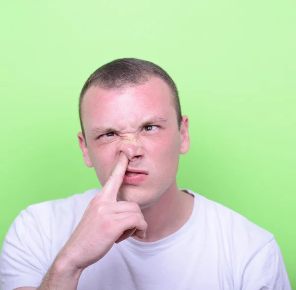 Parmağını burnuna olan genç bir adam portresi — Stok fotoğraf