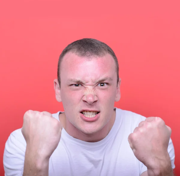 Portrait of angry man screaming showing fist against red backgro — Stock Photo, Image