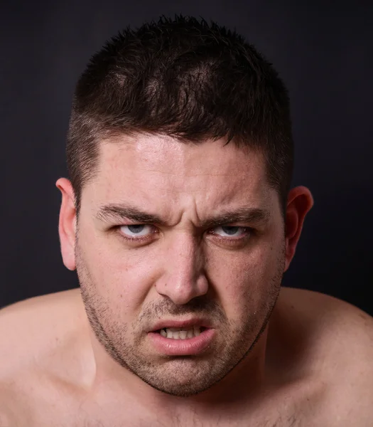 Portrait of angry man against dark background — Stock Photo, Image