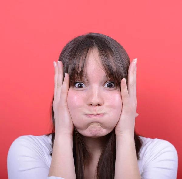 Portret van verbaasd meisje tegen rode achtergrond — Stockfoto