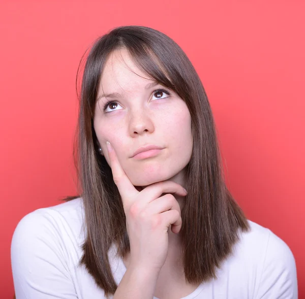 Portrait of beautiful girl looking above and thinking against re — Stock Photo, Image