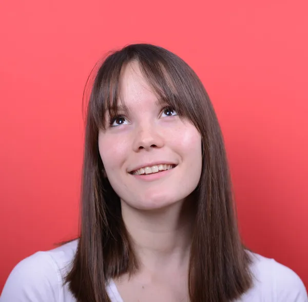 Retrato de una hermosa chica mirando sobre fondo rojo — Foto de Stock