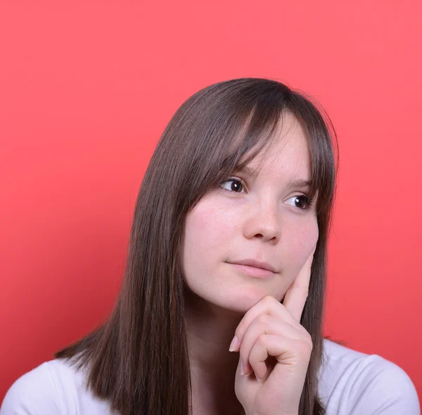 Porträt eines schönen Mädchens, das vor rotem Hintergrund denkt — Stockfoto