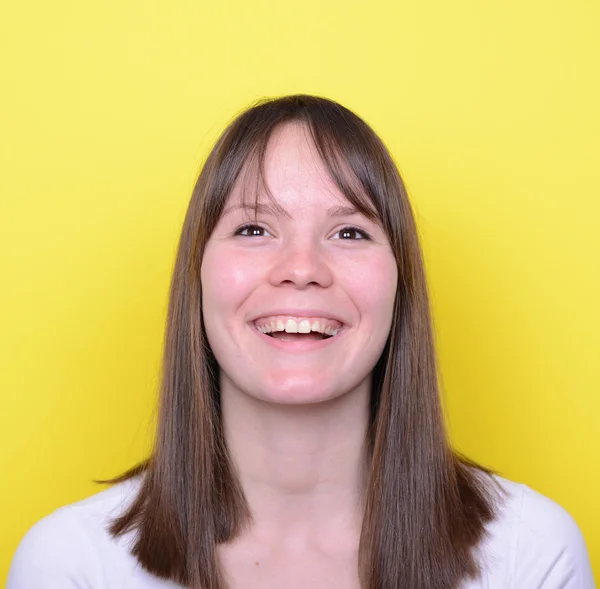 Retrato de una hermosa joven sonriendo contra un fondo amarillo — Foto de Stock