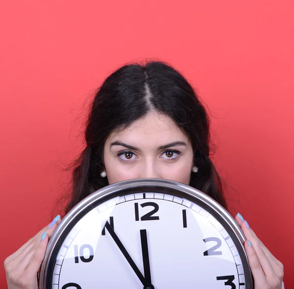 Portrait of girl holding huge office clock against red backgroun — Stock Photo, Image
