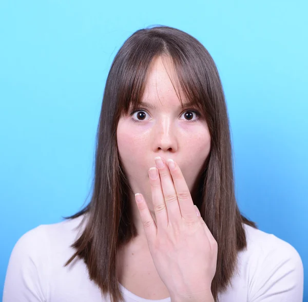 Portret van meisje met schok gebaar tegen blauwe achtergrond — Stockfoto