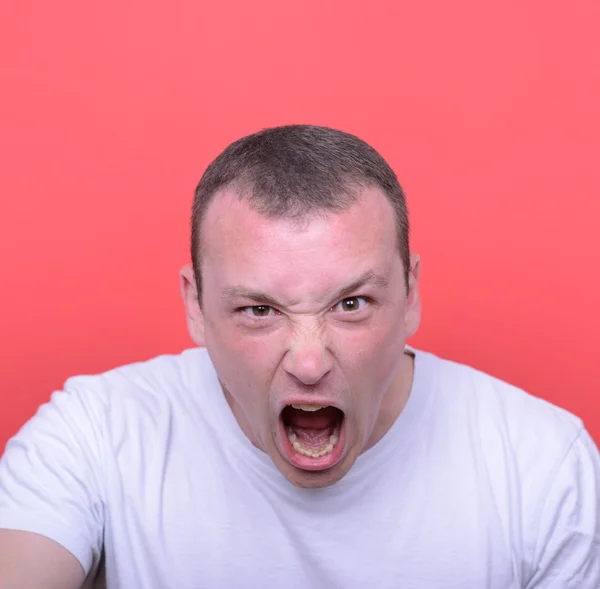 Портрет разгневанного человека, кричащего на красном фоне Лицензионные Стоковые Изображения