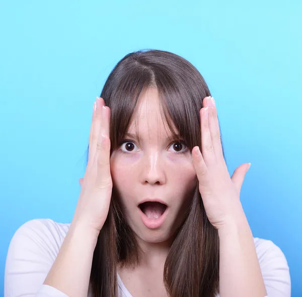 Portrait of girl with shock gesture against blue background — Stock Photo, Image