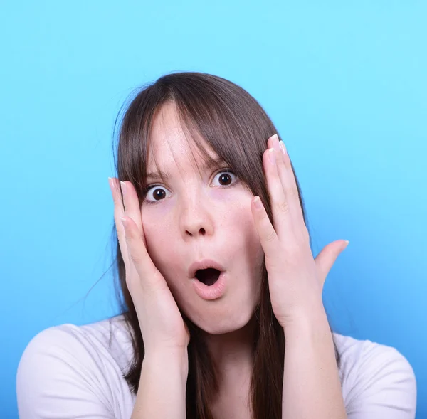 Porträt eines Mädchens mit Schockgeste vor blauem Hintergrund — Stockfoto