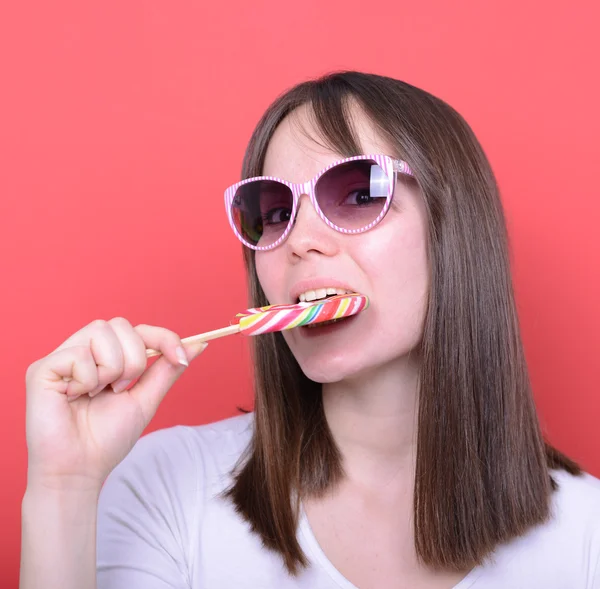 Portrait of woman with retro glasses and lollipop against red ba — Stock Photo, Image