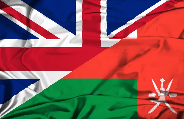 Waving flag of Oman and UK — Stock Photo, Image