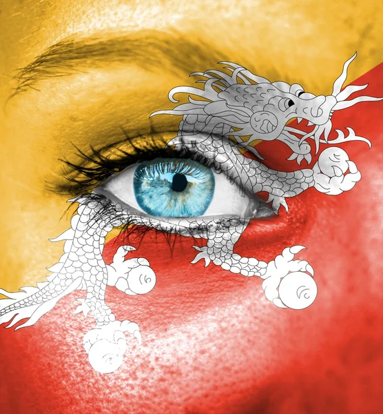 Woman face painted with flag of Bhutan — Stock Photo, Image