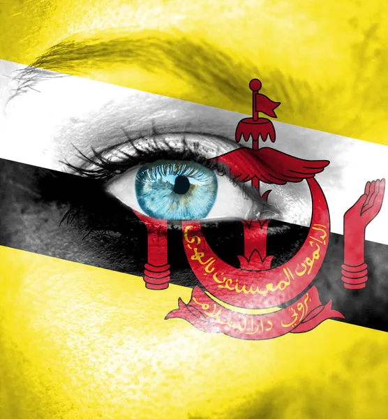 Woman face painted with flag of Brunei — Stock Photo, Image