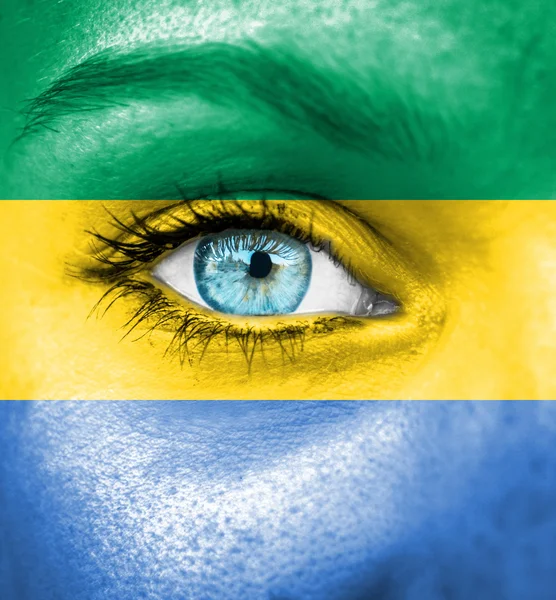 Vrouw gezicht beschilderd met vlag van gabon — Stockfoto