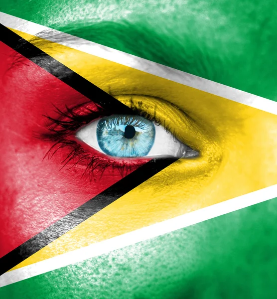 Woman face painted with flag of Guyana — Stock Photo, Image