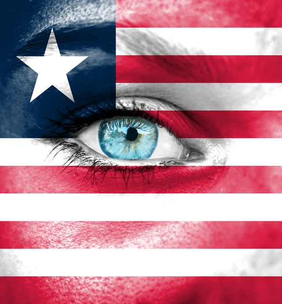 Vrouw gezicht beschilderd met vlag van liberia — Stockfoto