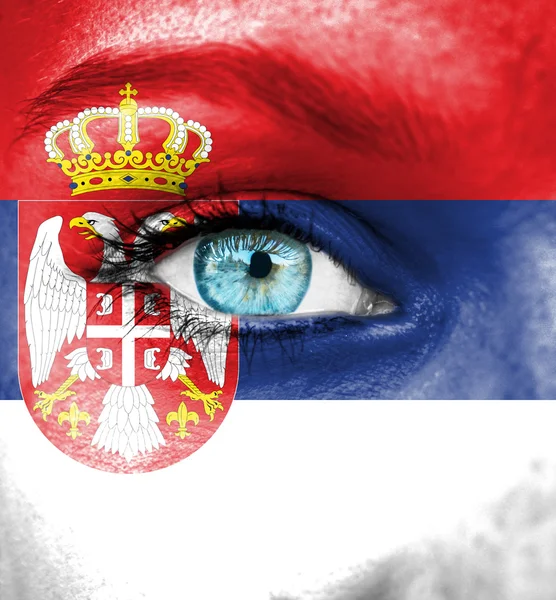Vrouw gezicht beschilderd met vlag van Servië — Stockfoto