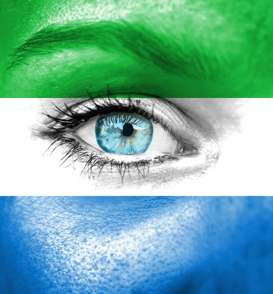 Woman face painted with flag of Sierra Leone — Stock Photo, Image