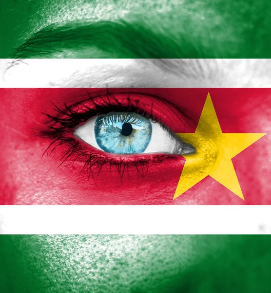 Woman face painted with flag of Suriname — Stock Photo, Image