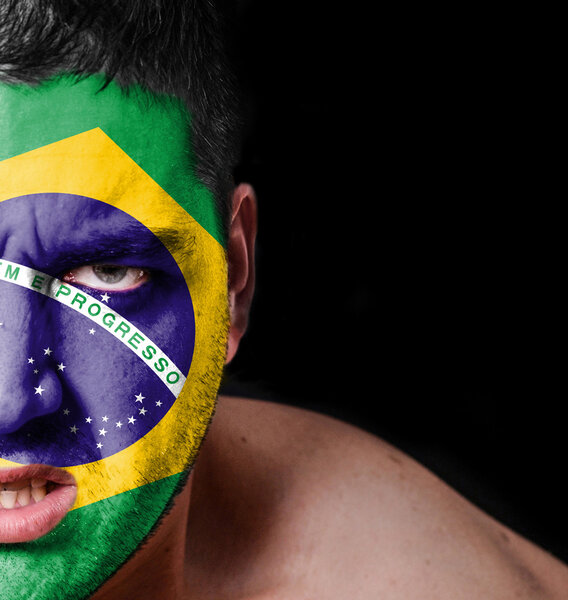 Портрет разгневанного человека с раскрашенным флагом Бразилии
