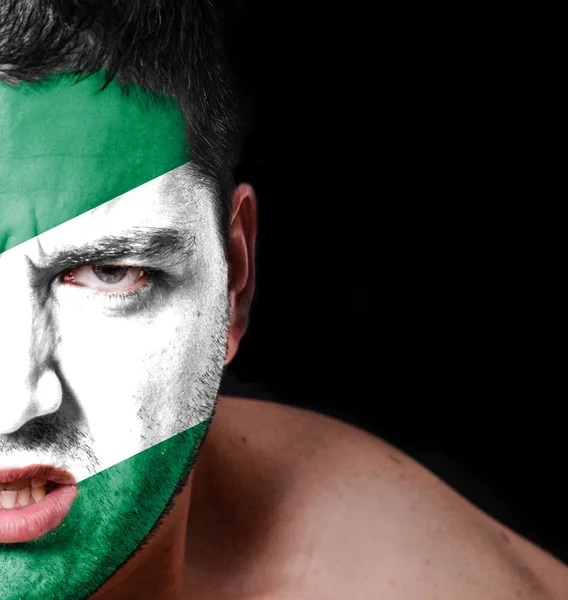 Portrait of angry man with painted flag of Nigeria — Stock Photo, Image