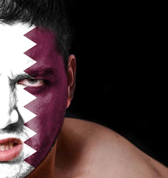 Portrait of angry man with painted flag of Qatar — Stock Photo, Image