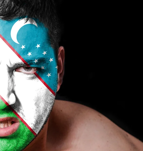 Portrait of angry man with painted flag of Uzbekistan — Stock Photo, Image