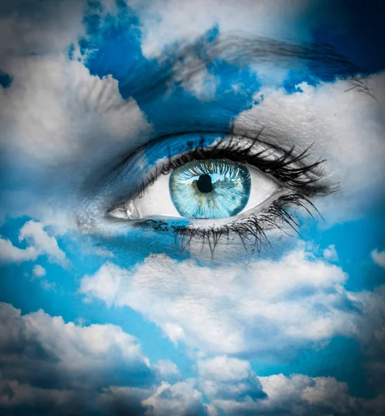 Schönes blaues Auge gegen blaue Wolken - spirituelles Konzept — Stockfoto