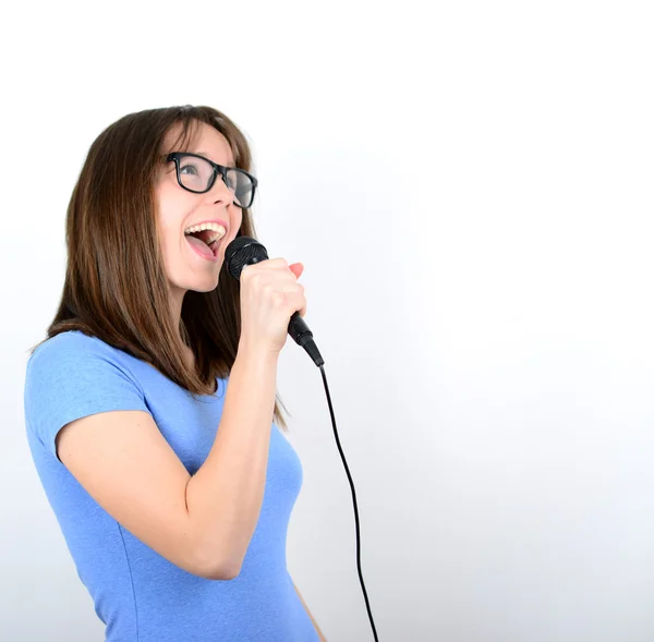 Portrait of a young female with microphone against white backgro — Stock Photo, Image