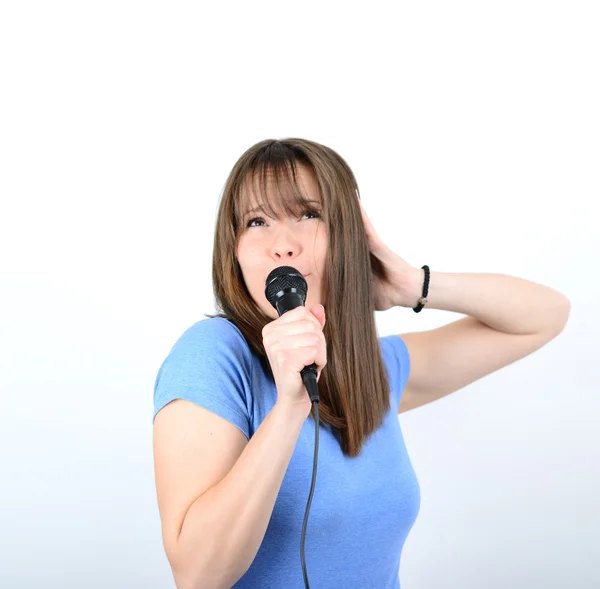 Portret van een jonge vrouw met microfoon tegen witte backgro — Stockfoto