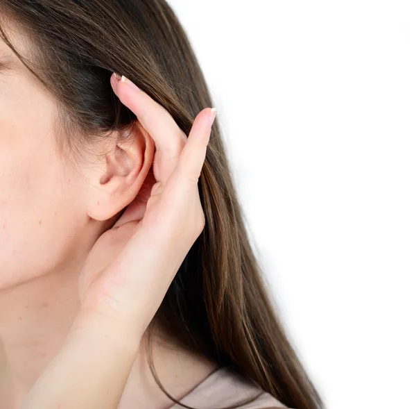 Woman holds her hand near ear and listens — Stock Photo, Image