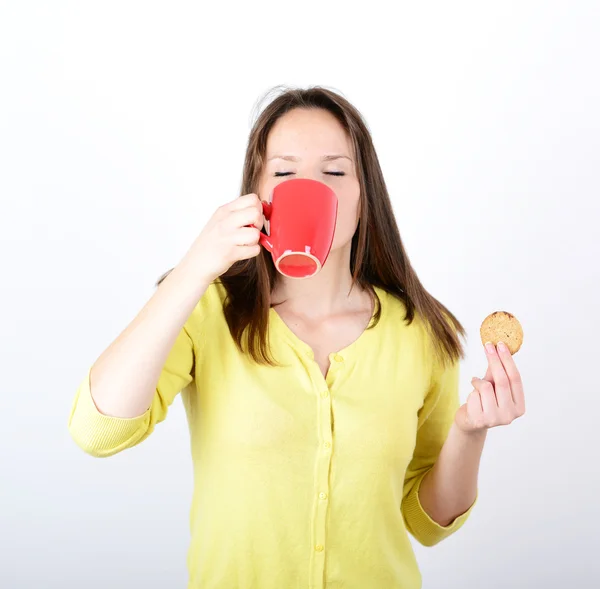 Vacker kvinna med kakor och kaffe mot vita backgro — Stockfoto